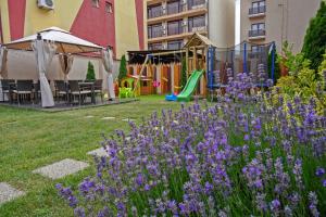 a garden with purple flowers and a playground at Coquette VILLA Mamaia Nord in Mamaia Sat/Năvodari