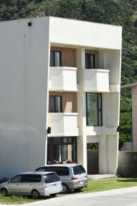 two cars parked in front of a white building at Living my life Hostel in Green Island