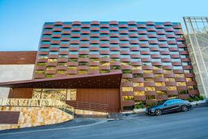 a building with a car parked in front of it at Maximus Hotel Byblos in Jbeil