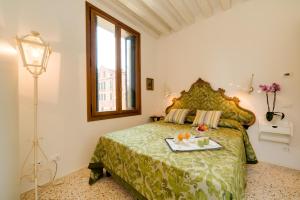 a bedroom with a bed with a tray of food on it at Ca' Dorina Luxury in Venice