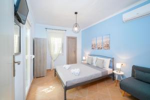 ein blaues Schlafzimmer mit einem Bett und einem Sofa in der Unterkunft Kritiri House in Skala Kallirachis