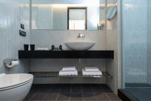 a bathroom with a sink, toilet and bathtub at NYX Herzliya in Herzliya