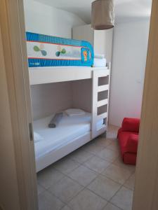 a bunk bed in a room with a red couch at Apartments Mestrovic in Lopar