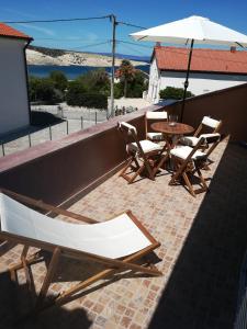 a patio with a table and chairs and an umbrella at Apartments Mestrovic in Lopar