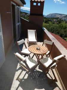 a table and chairs on a balcony with a view at Apartments Mestrovic in Lopar