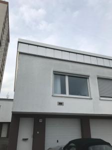 Casa blanca con ventana y coche en Apartment Friedrich 1201, en Mainaschaff
