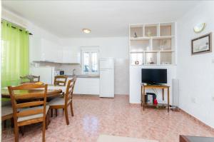 a kitchen and dining room with a table and a refrigerator at Classy Apartment Center in Split
