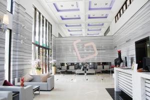 a lobby with couches and a large pink sign on the wall at Yundeng Landscape Hotel in Fanlu