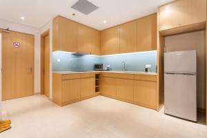 a kitchen with wooden cabinets and a refrigerator at The Ocean Apartment IDCWH B602 in Danang