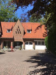 una gran casa de ladrillo con techo rojo en Le Pigeonnier, maison d'hôtes et Spa, en Croix