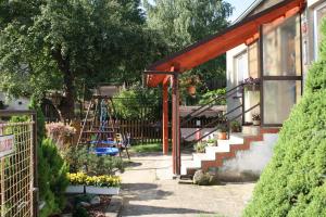 a garden with a house with a ladder and flowers at Chalupa Boskovice in Boskovice
