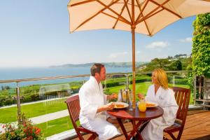 
a man and woman sitting at a picnic table at The Carlyon Bay Hotel and Spa in St Austell
