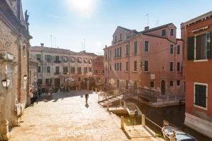 uma pessoa a descer uma rua ao lado de um canal em Ca' Dorina Luxury em Veneza