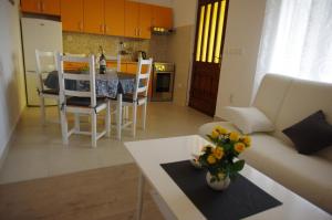 a living room with a couch and a table with flowers at Apartments Sonja Podgora in Podgora