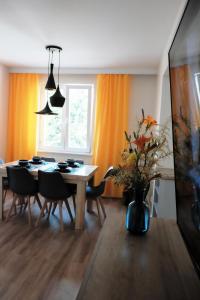 a dining room with a table and chairs and a vase with flowers at Apartament Mieszczański in Sandomierz