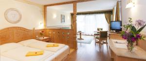 Habitación de hotel con 2 camas y TV en Landhotel Tharerwirt, en Valdaora