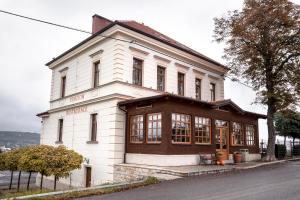 ein großes weißes Gebäude mit Fenstern auf einer Straße in der Unterkunft Penzion Marjána in Mníšek pod Brdy