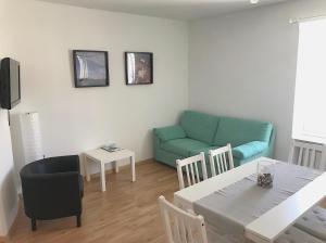 sala de estar con mesa y sofá azul en Apartment Tartini, en Piran
