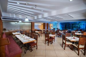 a dining room with tables and chairs in a restaurant at Hotel Elite Palazzo in Kāladi +22 photos
