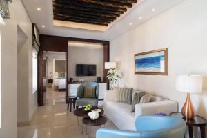 ドーハにあるSouq Al Wakra Hotel Qatar By Tivoliのリビングルーム(ソファ、椅子、テレビ付)