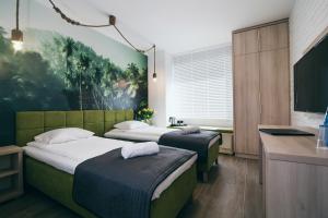 a hotel room with two beds and a tv at Green Village w Aquapark Reda in Reda
