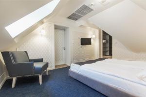 a bedroom with a large bed and a chair at Hotel Villa Baltica in Sopot +67 photos
