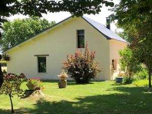 Casa blanca con patio con césped y árboles en Gîte Le Clos de la Bertinière, en Bosgouet