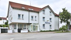 a white building on the side of a street at Appartis - Hotel am Stadtpark in Sindelfingen