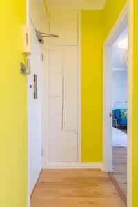 um quarto com paredes amarelas e uma porta branca em Chic 1 Bed Studio Flat in Popular Bloomsbury em Londres