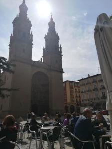 un gruppo di persone seduti ai tavoli di fronte a un edificio di NERALE Loft Downtown Plaza Mercado a Logroño