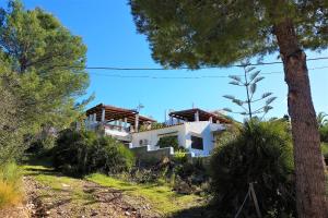 a house on the side of a hill with trees at Finca La Siesta - Villa in Betlem, Mallorca in Colonia de Sant Pere