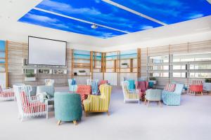 a waiting room with colorful chairs and a screen at Amadria Park Beach Hotel Jure in Šibenik