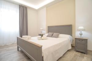 a bedroom with a large white bed and a window at Casa Solmes in Olbia