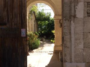 un accès à un bâtiment avec une arche dans l'établissement Le Posterlon, à Caumont-sur-Durance