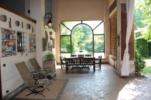 a living room with a table and chairs and windows at Corte Ginepro in Roncoferraro