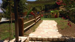 a parrot jumping over a fence in a yard at Nireas : Stone Villa in Zakynthos