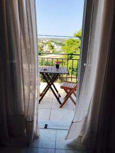 a view from the door of a balcony with a table at A&D Apartments in Porto Rafti