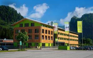 Explorer Hotel Hinterstoder في هينترستودر: مبنى به سيارات متوقفة أمامه