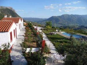 a row of white buildings with a river and mountains at Hacienda el Mirador in El Gastor