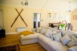 a living room with a couch and a large cross on the wall at Coldstream Estate - The Whare in Coldstream