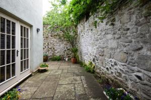 a stone wall with potted plants next to a window at Heather Brae in Kelso