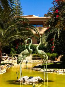 two statues of flamingos standing in the water at Apartamentos Turisticos Vila Palmeira in Lagos