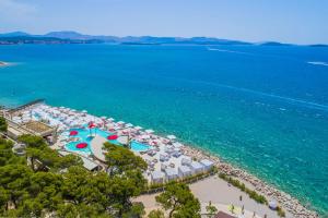 
a beach filled with lots of colorful umbrellas at Hotel Niko in Šibenik

