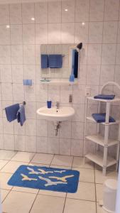 La salle de bains est pourvue d'un lavabo et d'un tapis bleu. dans l'établissement Ferien- und Reiterparadies Voßhörnerhof, à Neuschoo