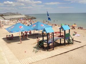 a group of people on a beach with blue umbrellas at Fontanka Apartment in Fontanka