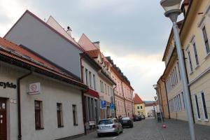 a street with buildings and cars parked on the street at Centrum Apartman LEYLA 6 in Bardejov