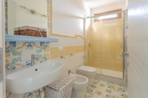 bagno con lavandino e servizi igienici di La Casetta in villa a Santa Maria di Castellabate