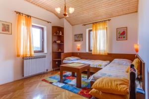 a bedroom with two beds and a table at Filip Apartment in Mali Lošinj