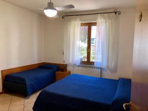 a bedroom with two blue beds and a window at Hotel La Toscana in Arezzo