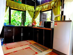 a kitchen with a refrigerator and some windows at Villa Sri Kampung in Kuah